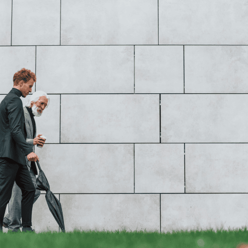 Two businessmen from different generations walking together, symbolising next-gen family office leadership transition Two businessmen from different generations walking together, symbolising next-gen family office leadership transition