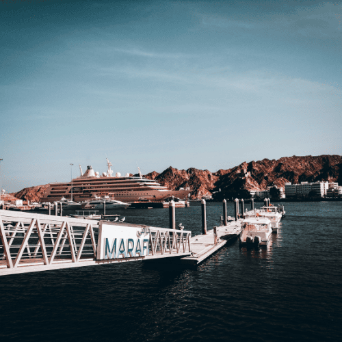 Harbour and marina in Oman with yachts and mountains in the background, representing Towell Group’s modernisation and global governance transformation with DiliTrust