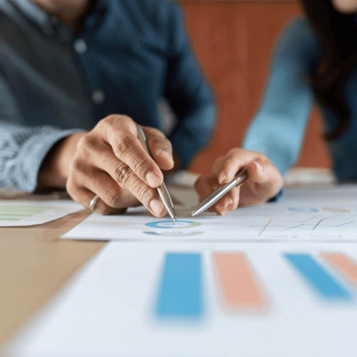 Two people reviewing financial charts and data, symbolising analysis and decision-making in family office venture capital strategy